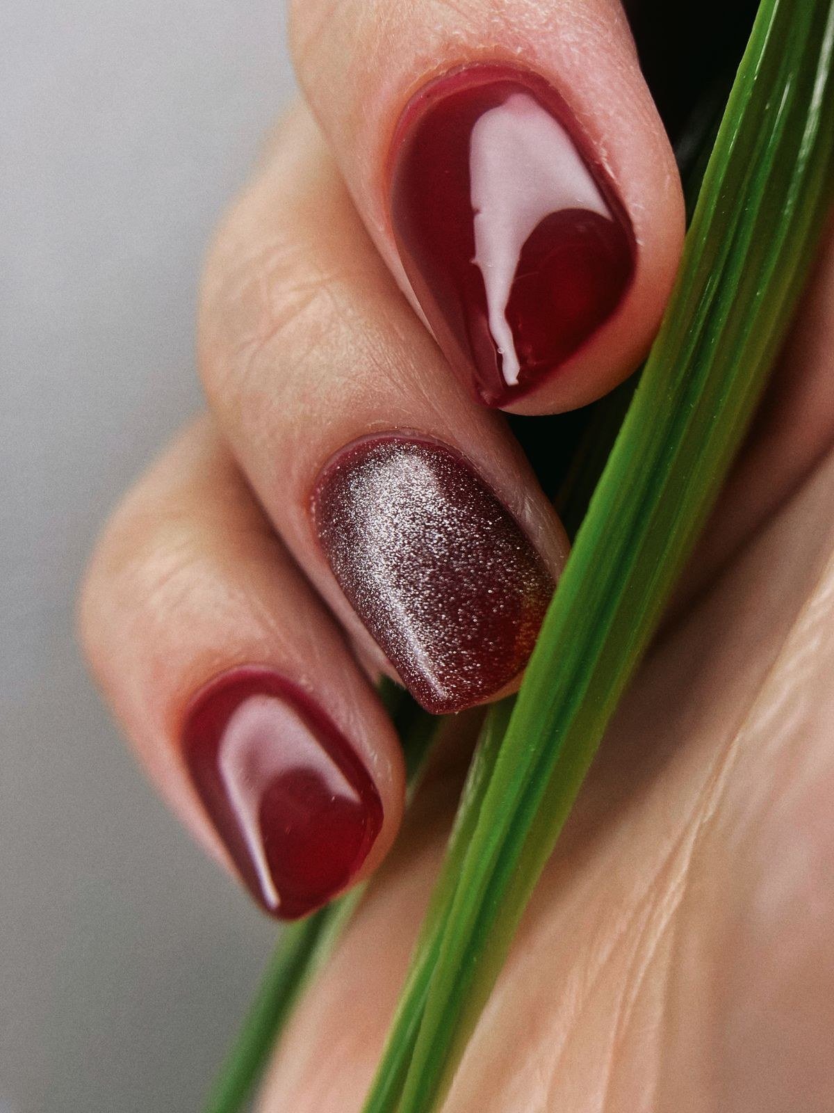 Nail art tools and jelly pink polish with chrome powder on a table
