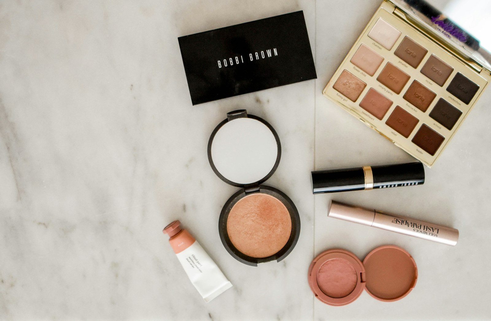 Flat lay of frosted makeup products and cosmetics on a light background