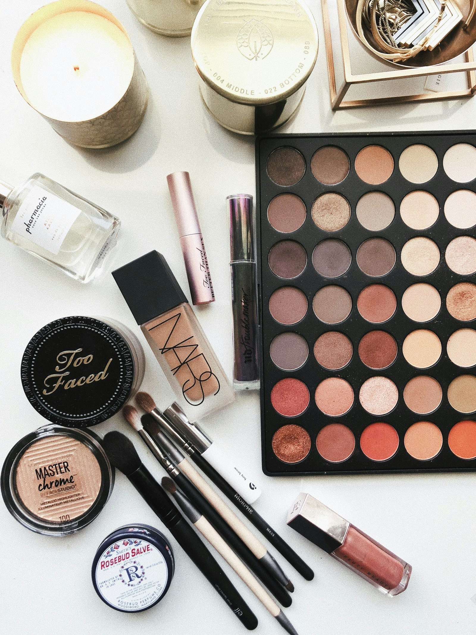 Cosmetic brushes and frosted beauty products arranged flat lay style