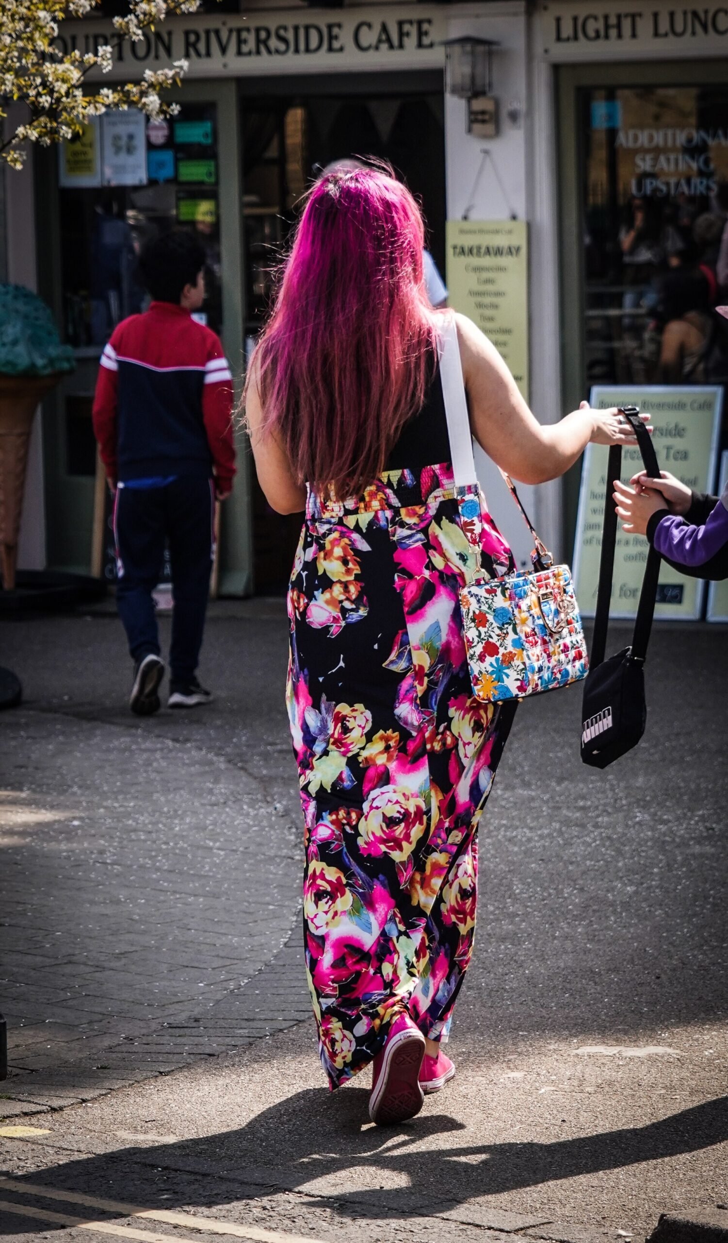 Smiling woman confidently showing off her finished pink hair stripe
