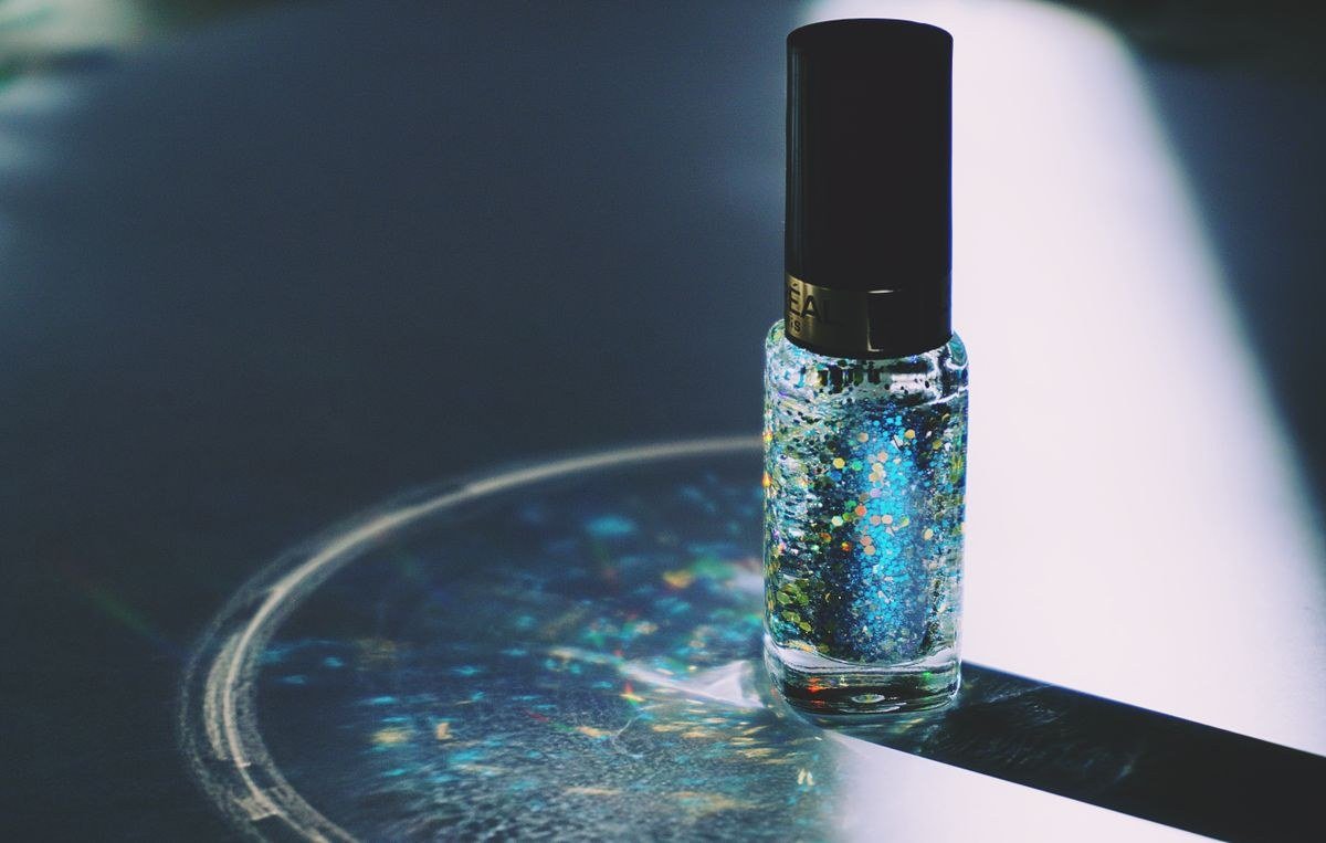 Nail magnet held over wet cat eye gel polish demonstrating magnetic effect