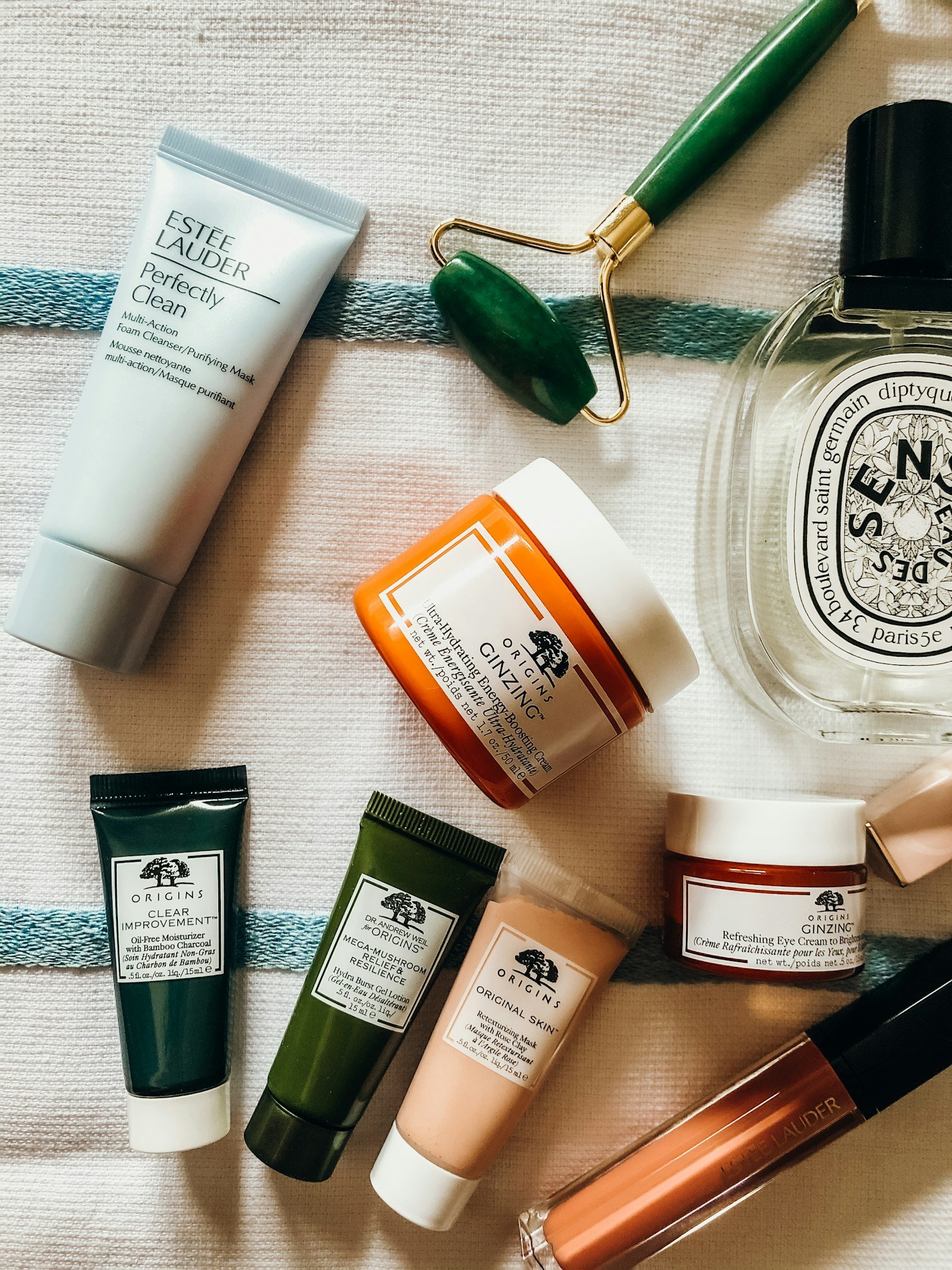 Skincare and perfume products in a soft pink aesthetic flat lay