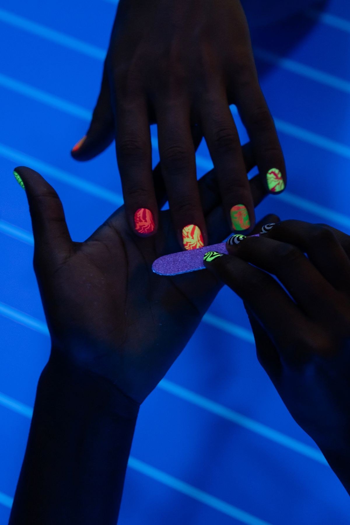 Salon professional applying hot pink chrome nails treatment