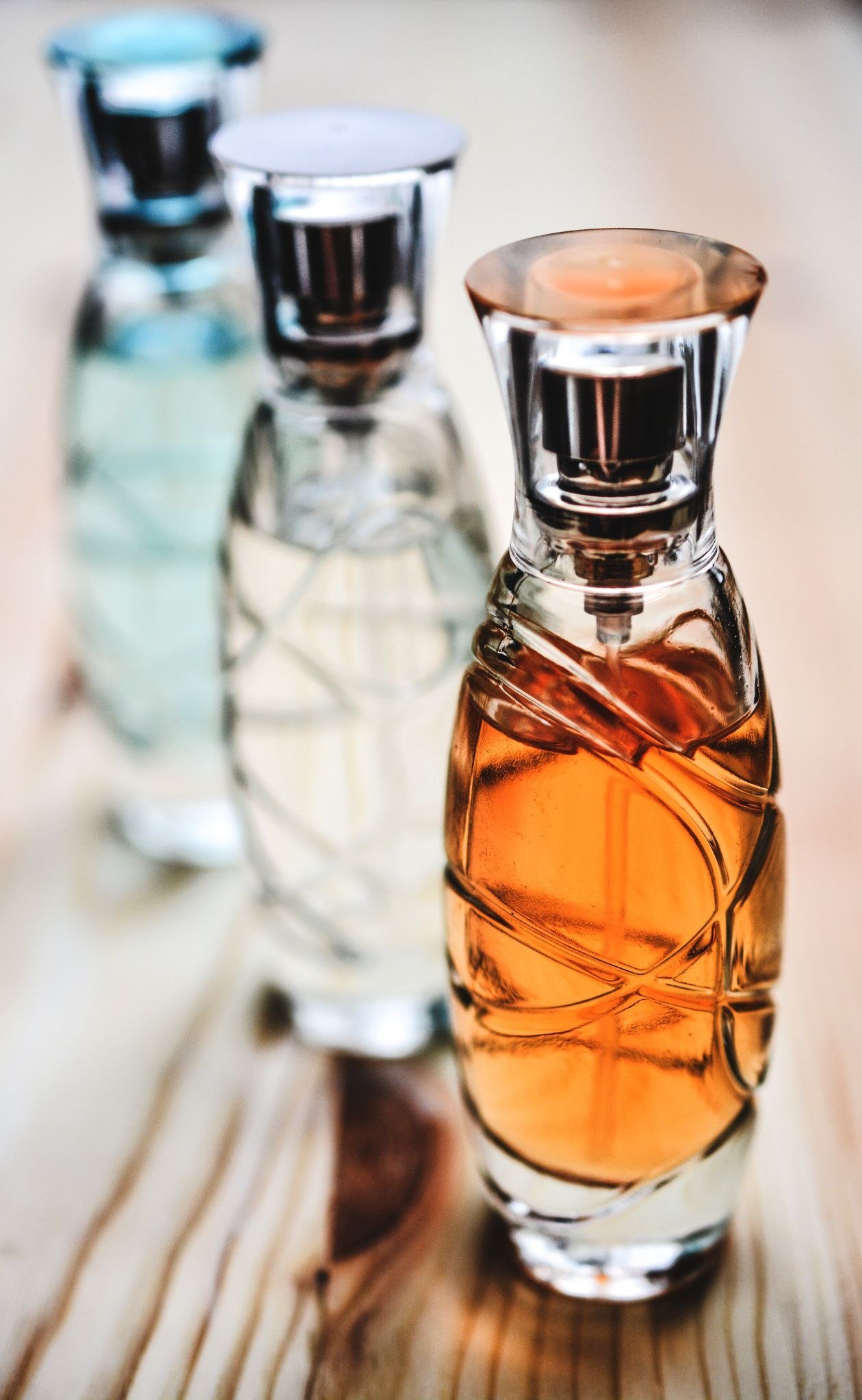 Beautiful collection of glass perfume bottles showcasing different fragrances on a wooden surface