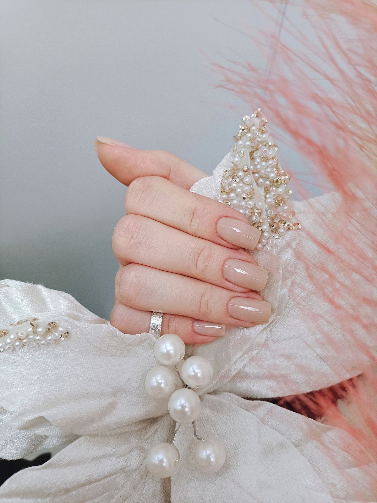 Short rounded caramel nude nails elongating the fingers