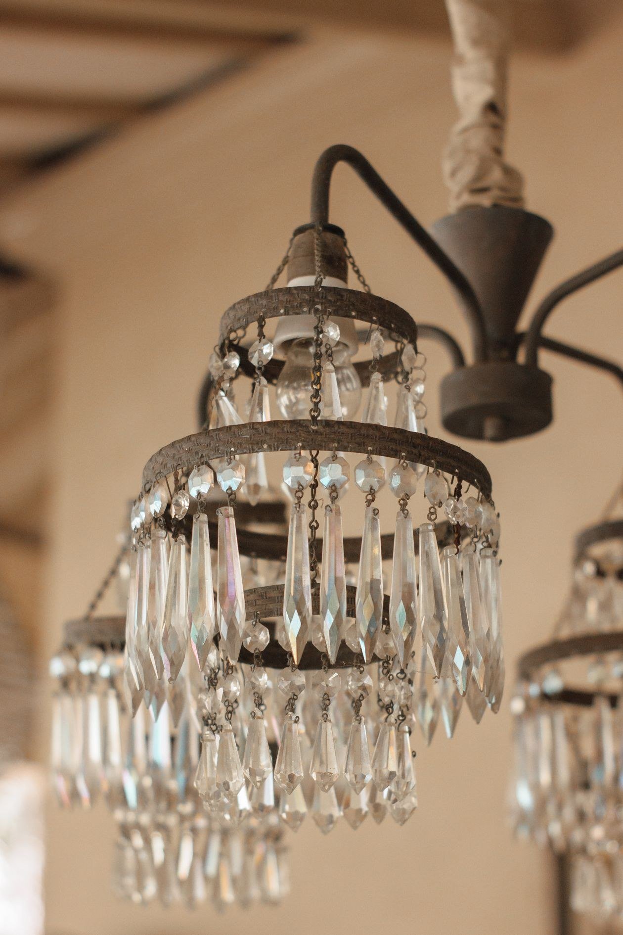 A close-up view of a vintage crystal chandelier with intricate glass details and warm lighting