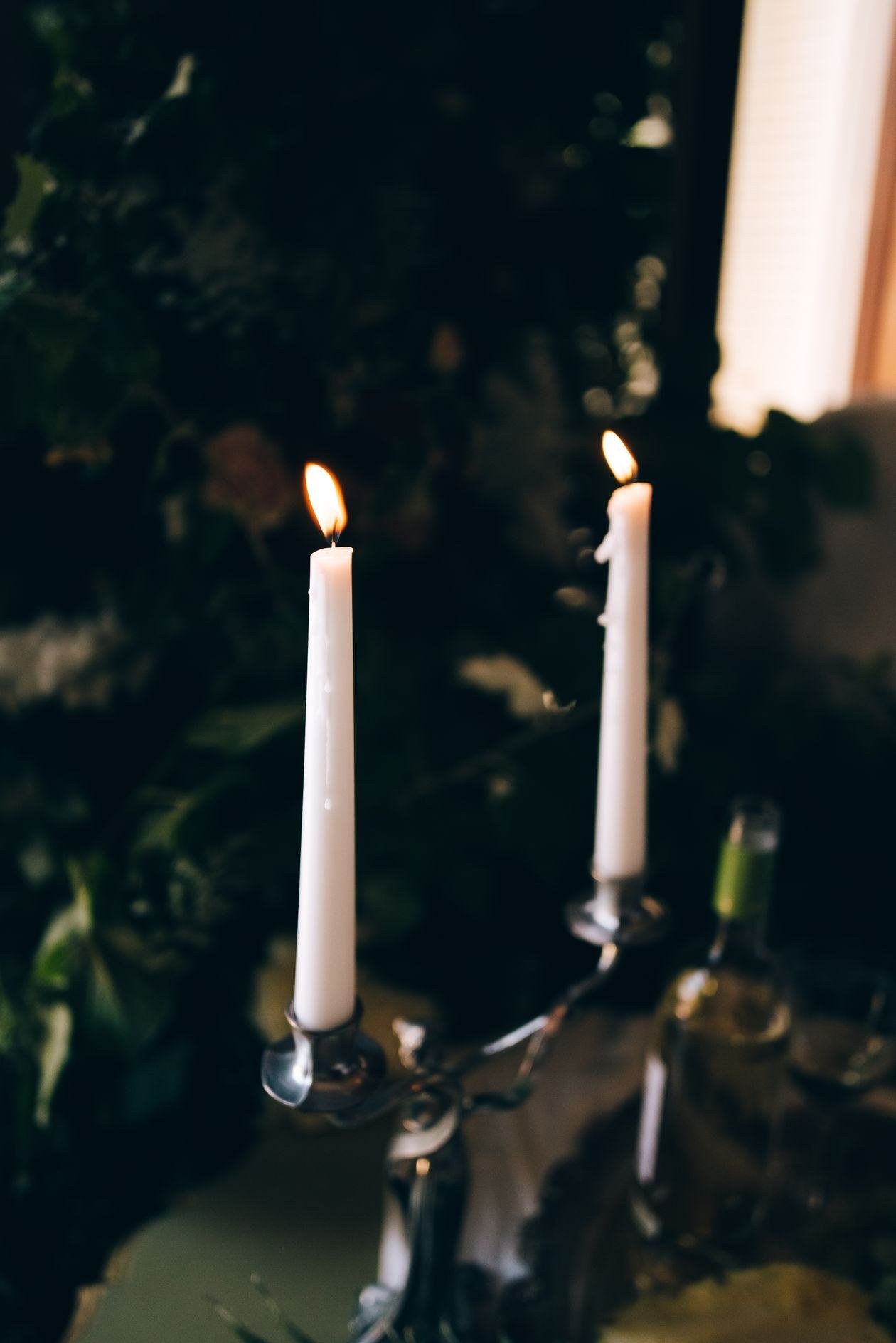 Warm candlelit ambiance with tall candles in a holder, perfect for a cozy evening
