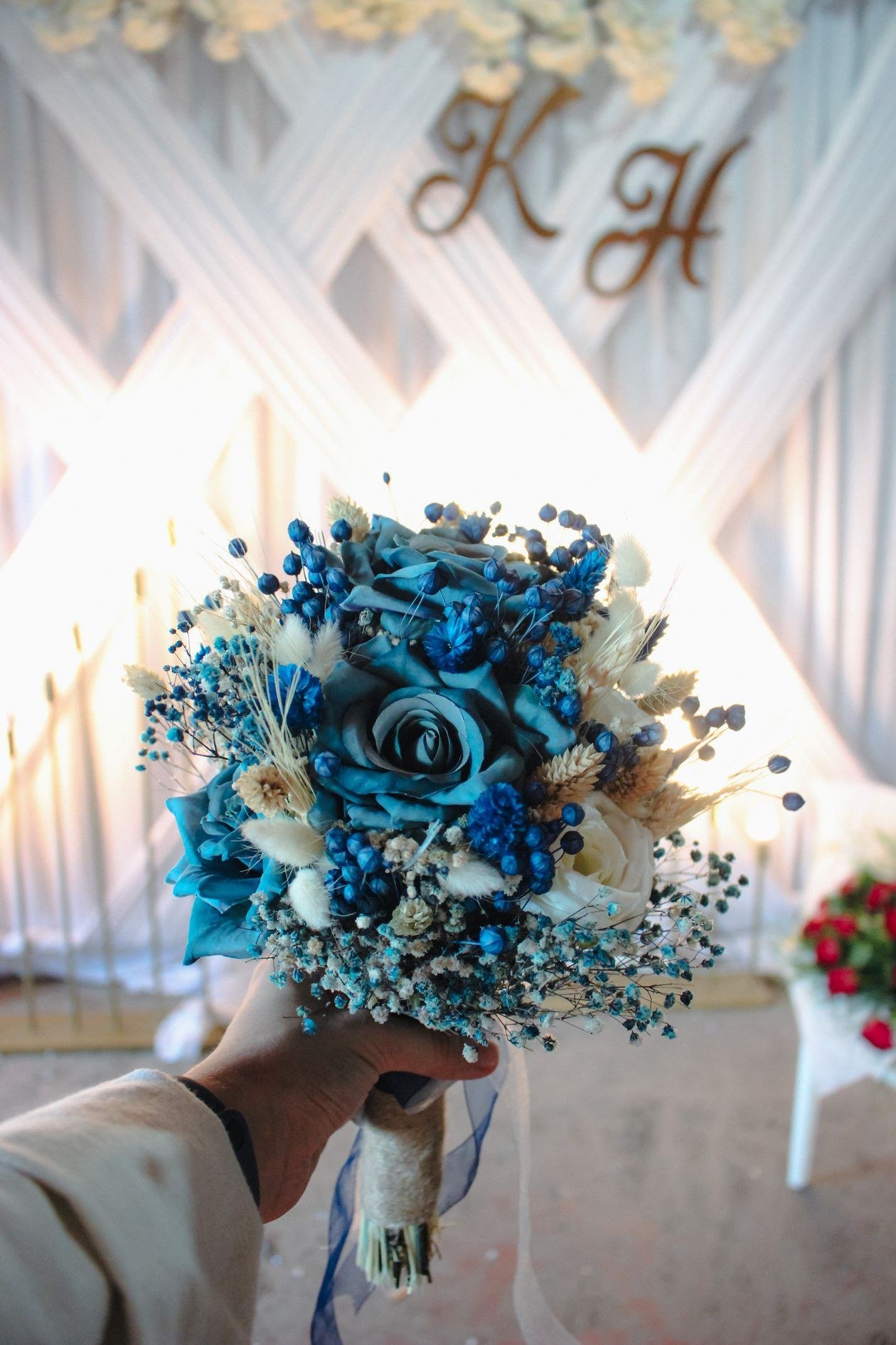 A close-up of a vibrant blue wedding bouquet held indoors