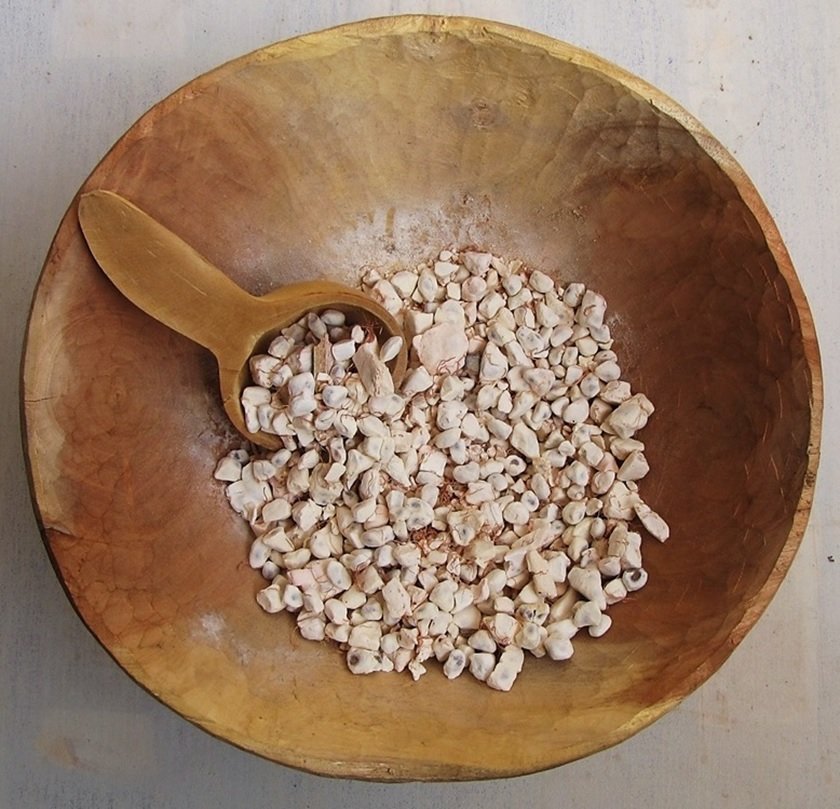 Rustic wooden bowl with grains and a wooden spoon