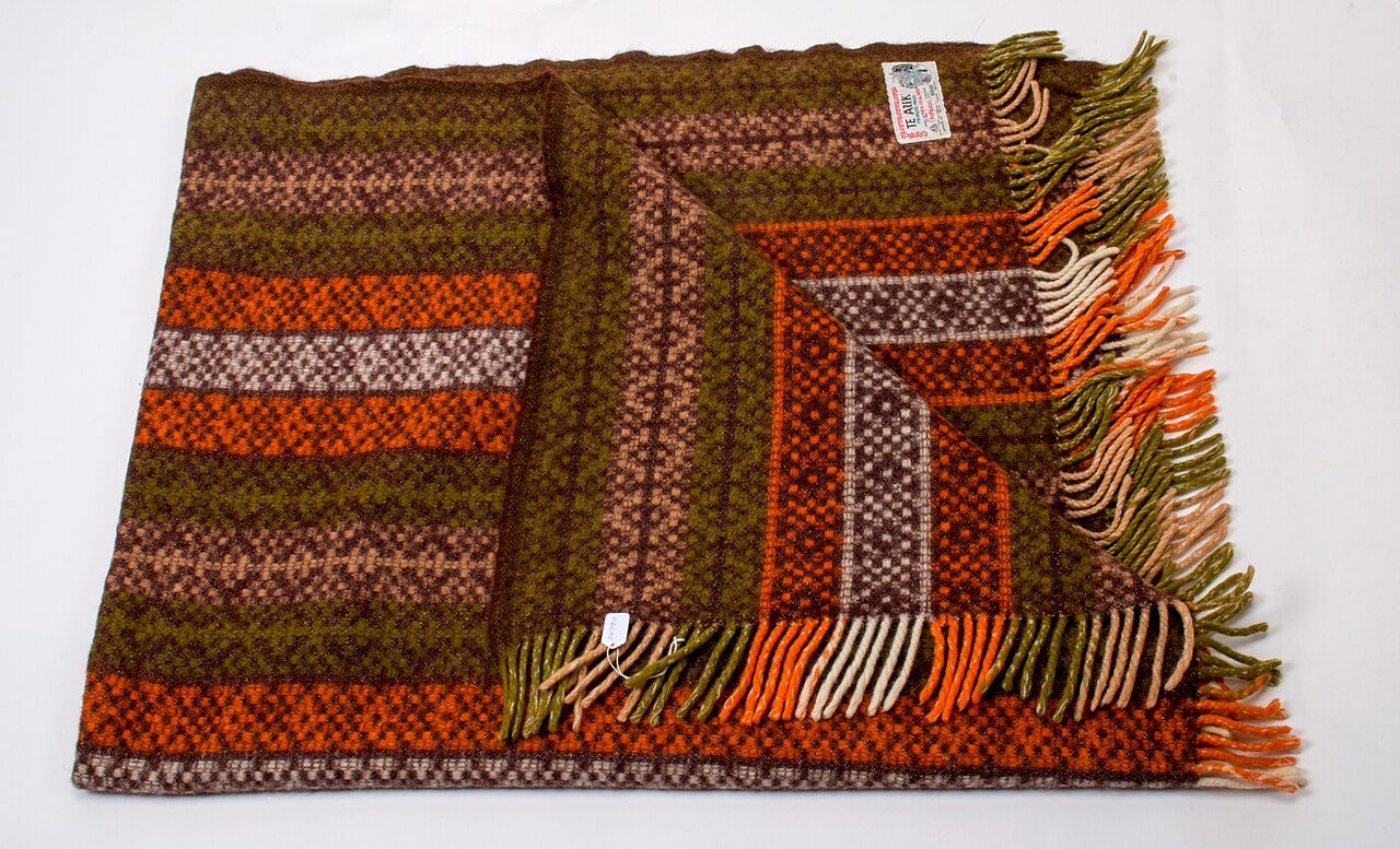 Woven wool throw blanket with fringe in earthy tones