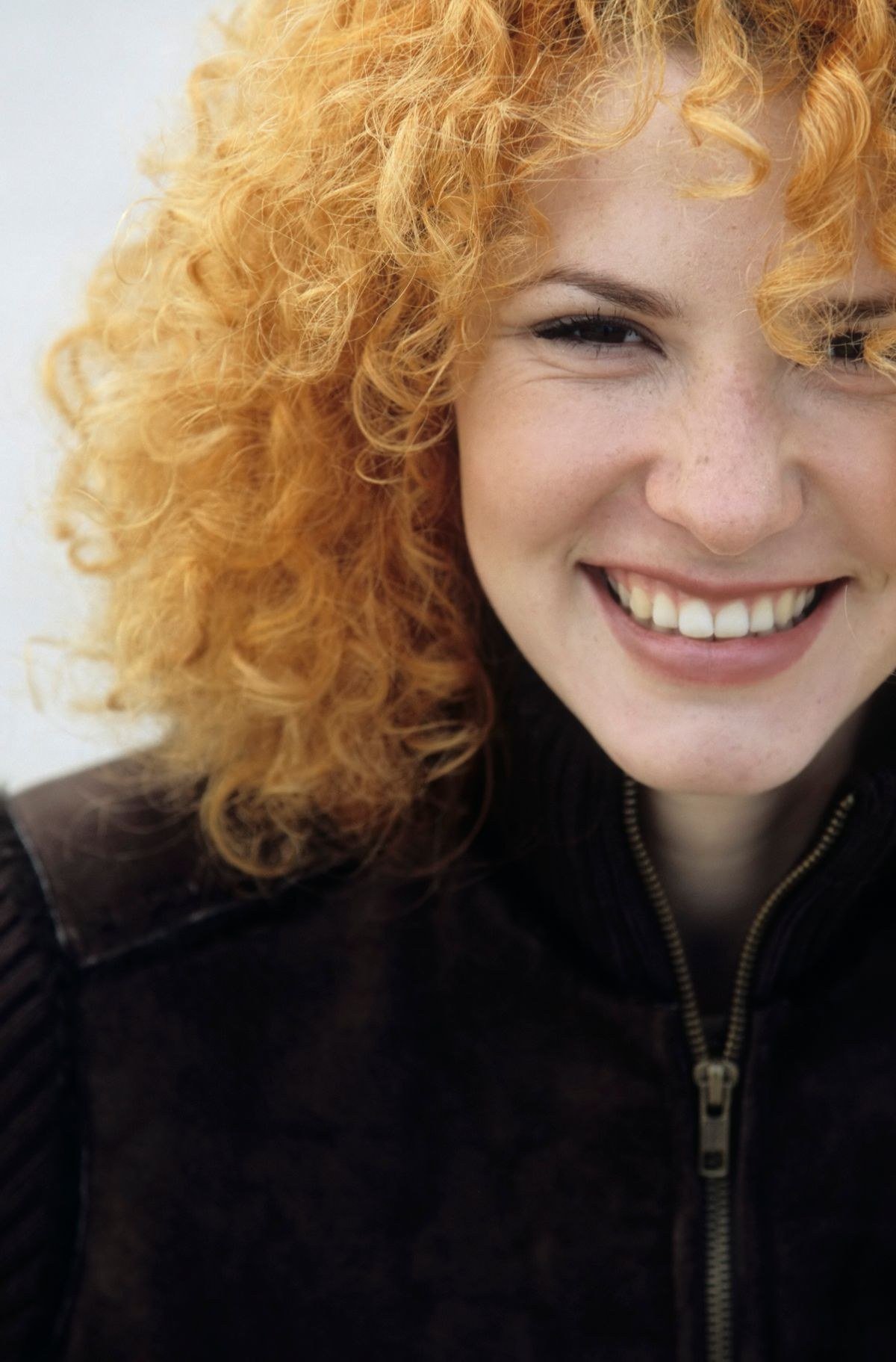 Hair colorist applying soft copper blonde color at salon