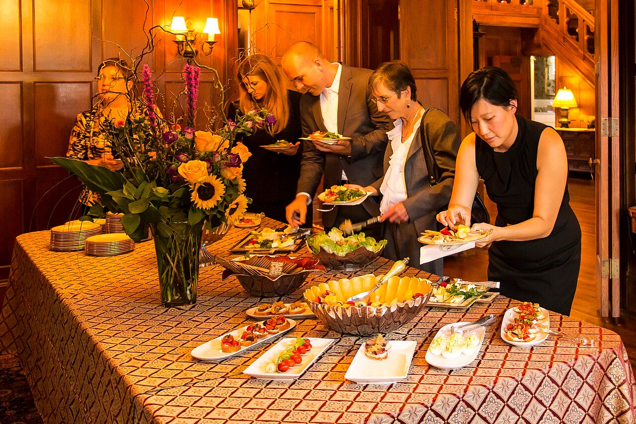 Party buffet table with guests serving food