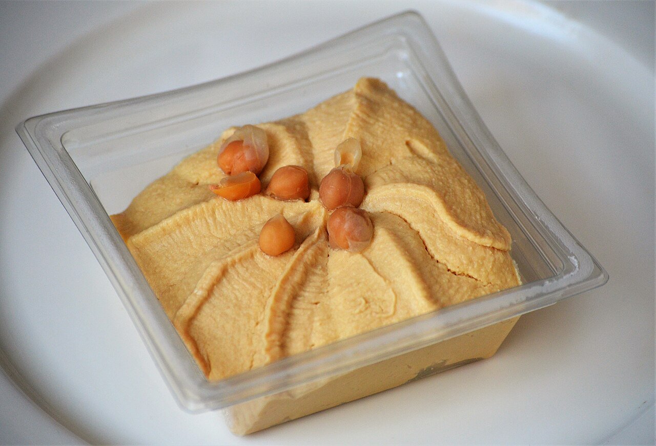 Container of hummus topped with chickpeas