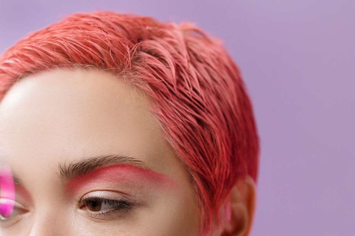 Subtle thin pink streaks woven through natural hair