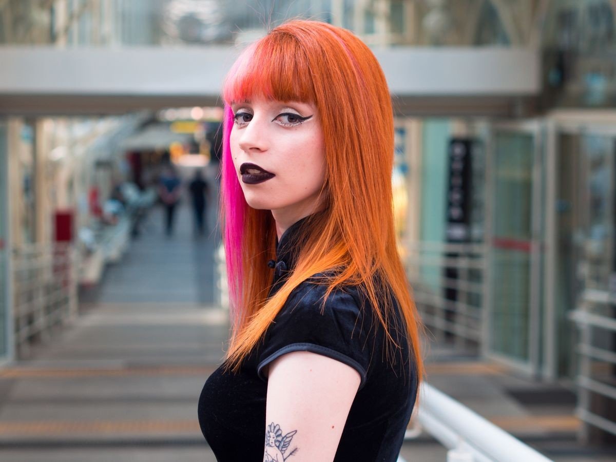 Pink streaks in curly hair with dimensional colour