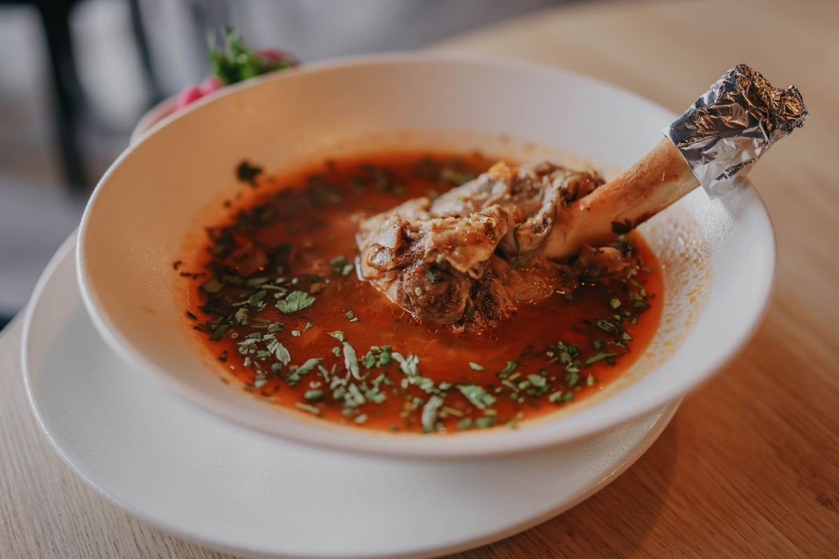 Homemade bone broth simmering with bones and vegetables