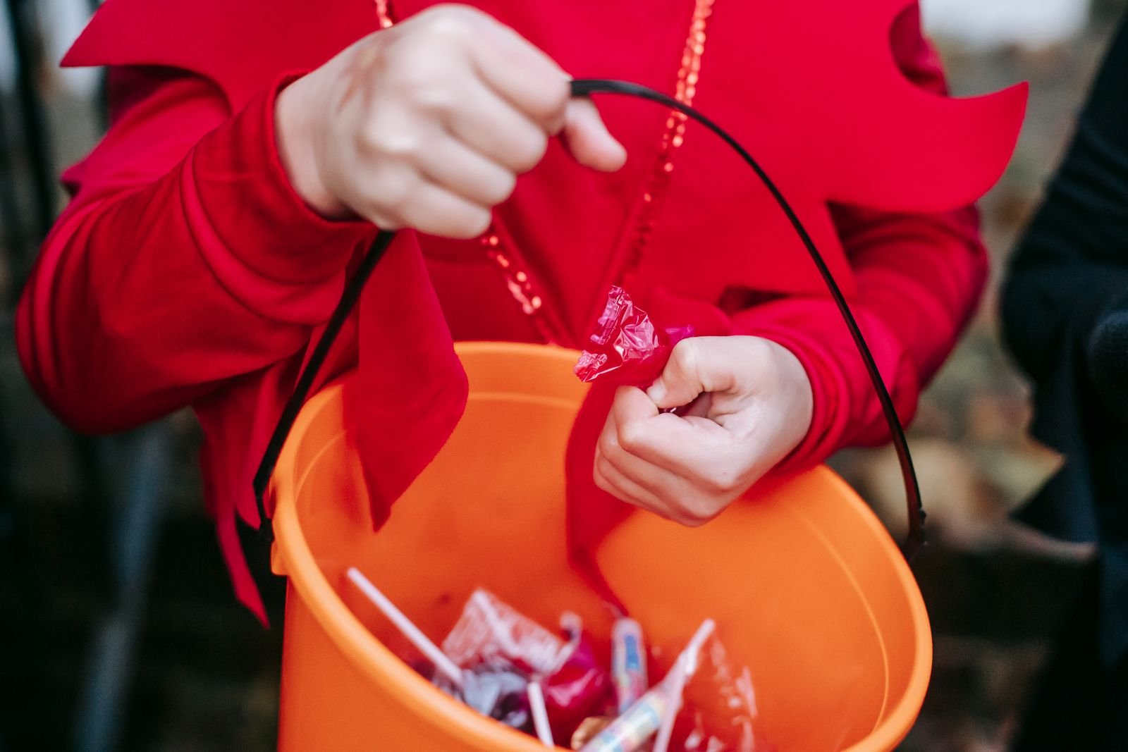 Children in retro Halloween costumes trick or treating at a decorated doorway