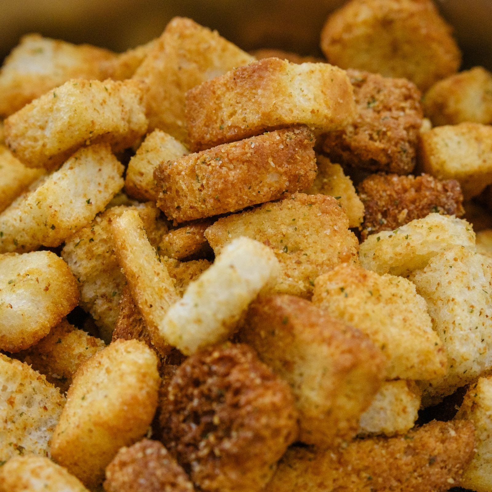 Cornbread cubes drying on a baking sheet in the oven