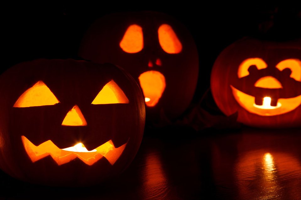 Heirloom pumpkins with traditional carved jack-o-lantern faces glowing