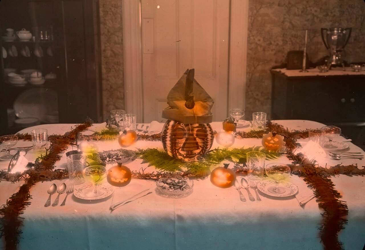 Nostalgic halloween dining tablescape with pumpkins candles and vintage linens