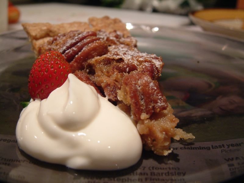 Slice of pecan pie cake showing moist layers and crunchy pecan topping