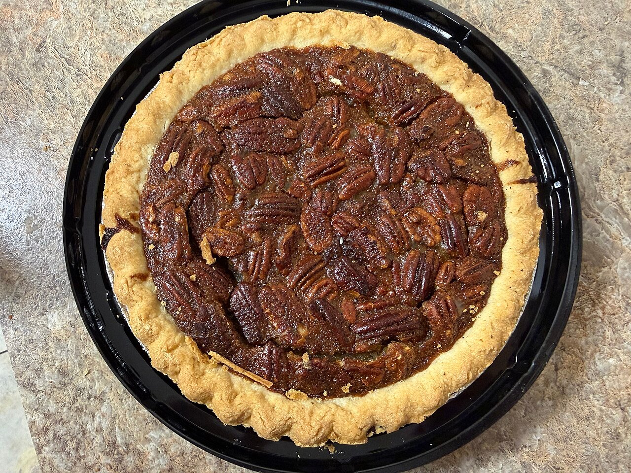 Creaming butter and sugar together in a mixing bowl for pecan pie cake