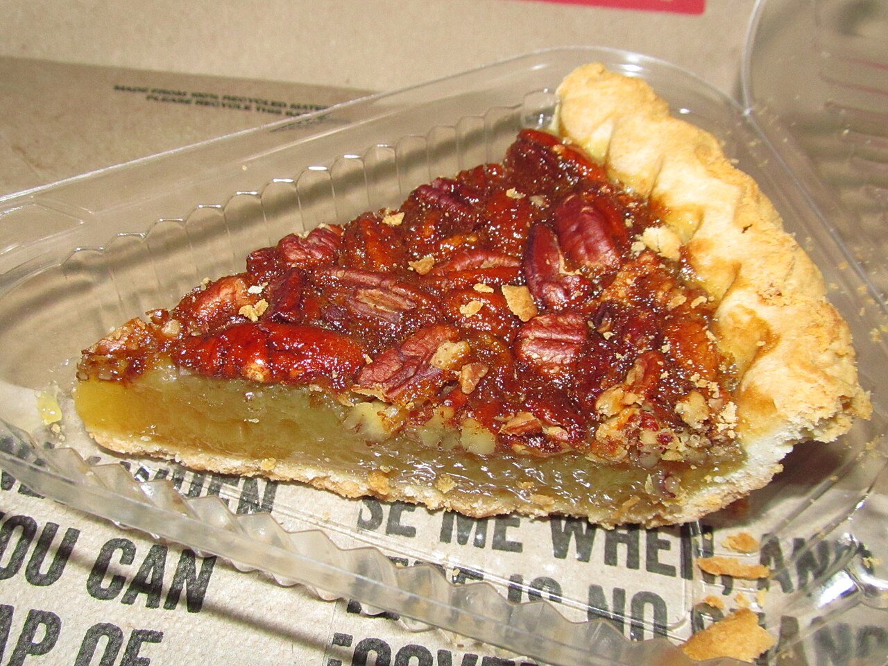 Gooey pecan pie filling with caramel sauce and chopped pecans in a saucepan