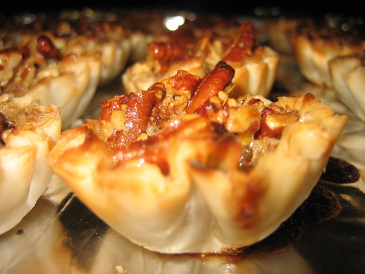 Assembling pecan pie cake layers with filling and frosting on a turntable