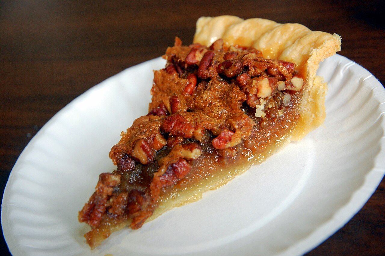 Serving slice of pecan pie cake with vanilla ice cream and coffee