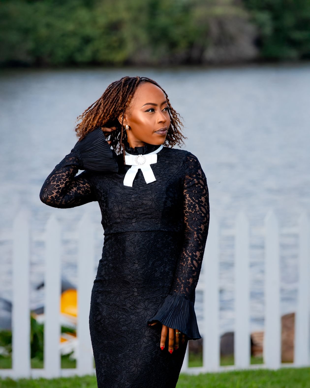 Woman in black lace dress by a tranquil riverside