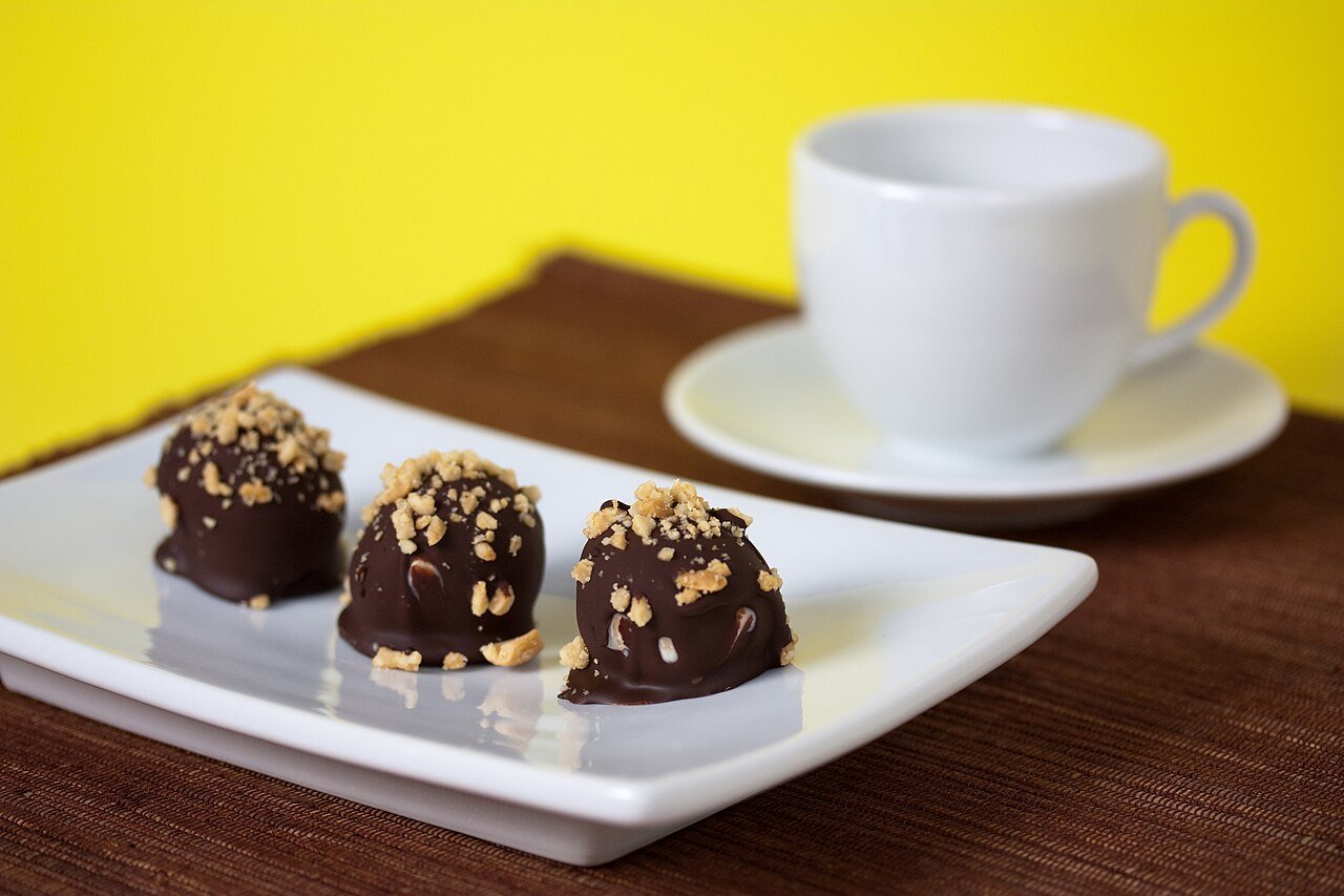 Butterfinger balls decorated with crushed candy drizzle and chocolate swirls