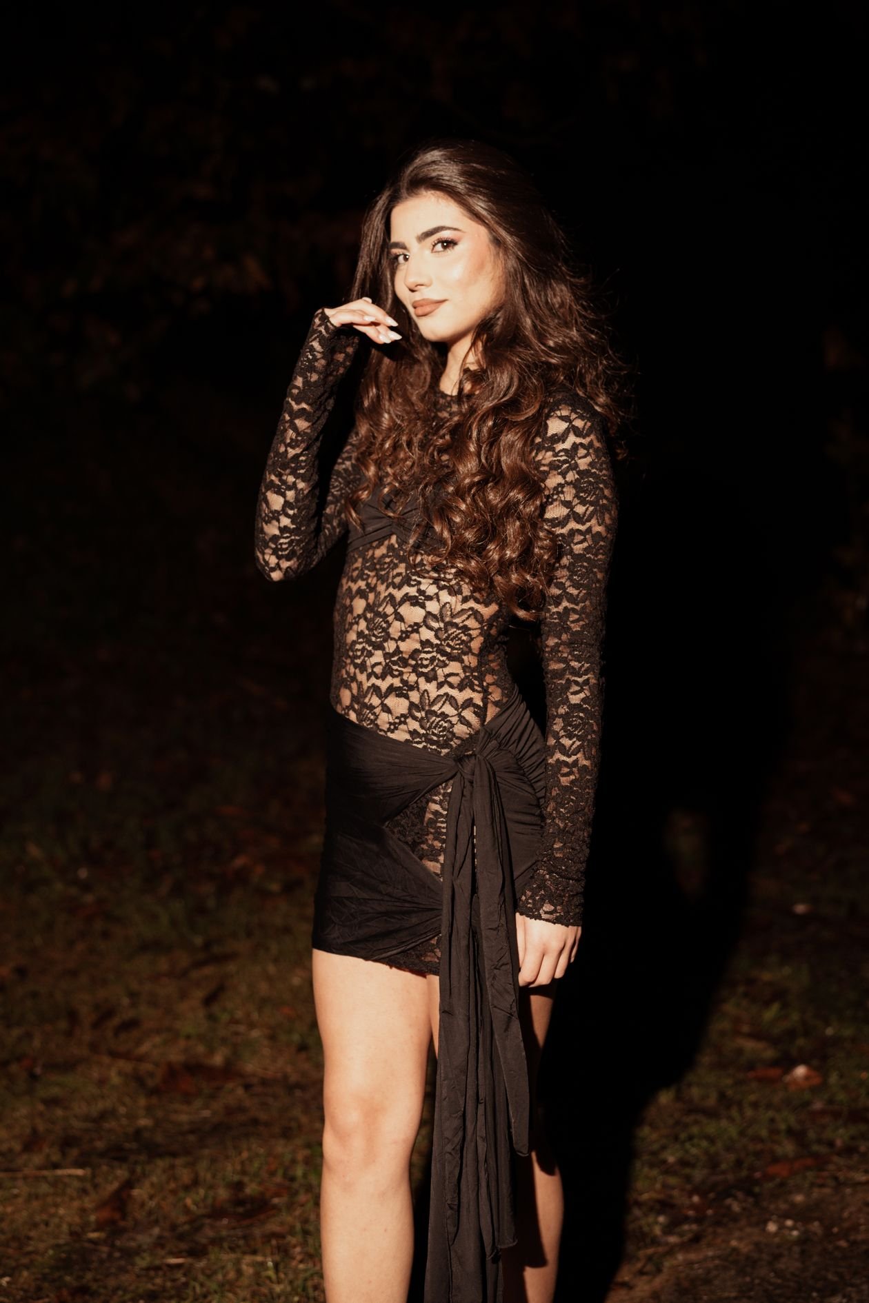 Glamorous woman in lace dress outdoors at night