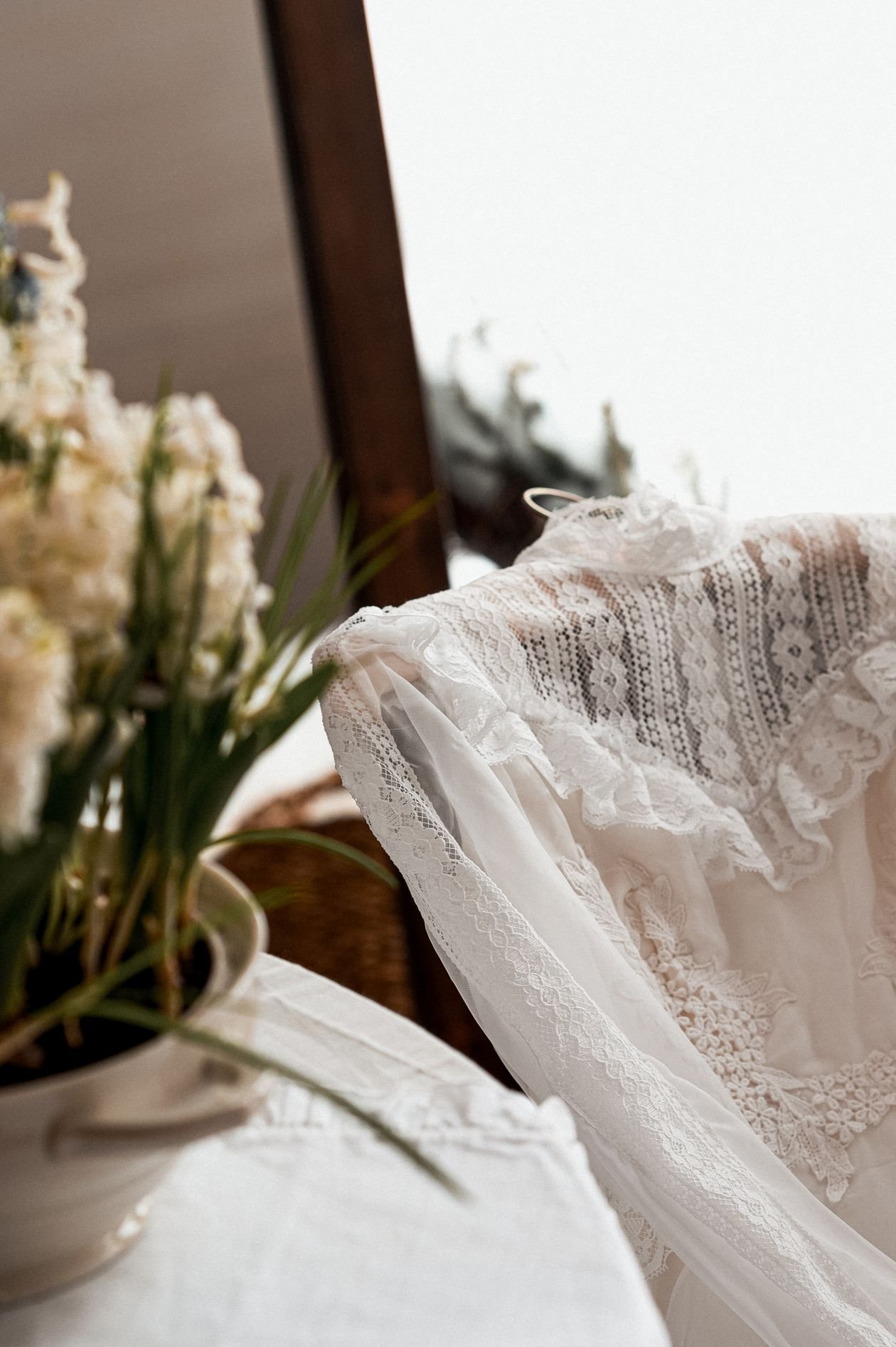 White lace dress draped over a chair, flat lay
