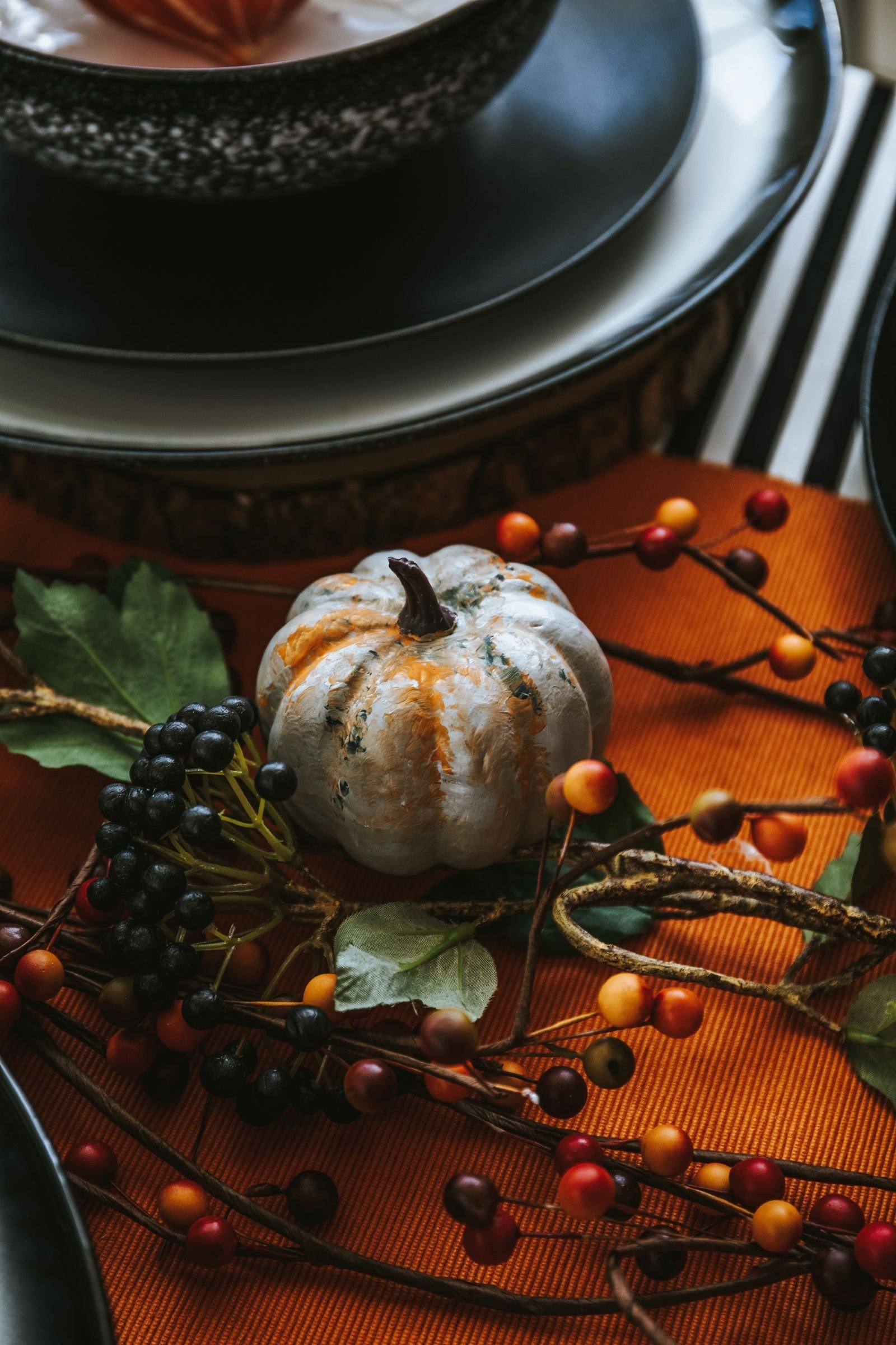 Centrepiece of small pumpkins gourds and autumn leaves