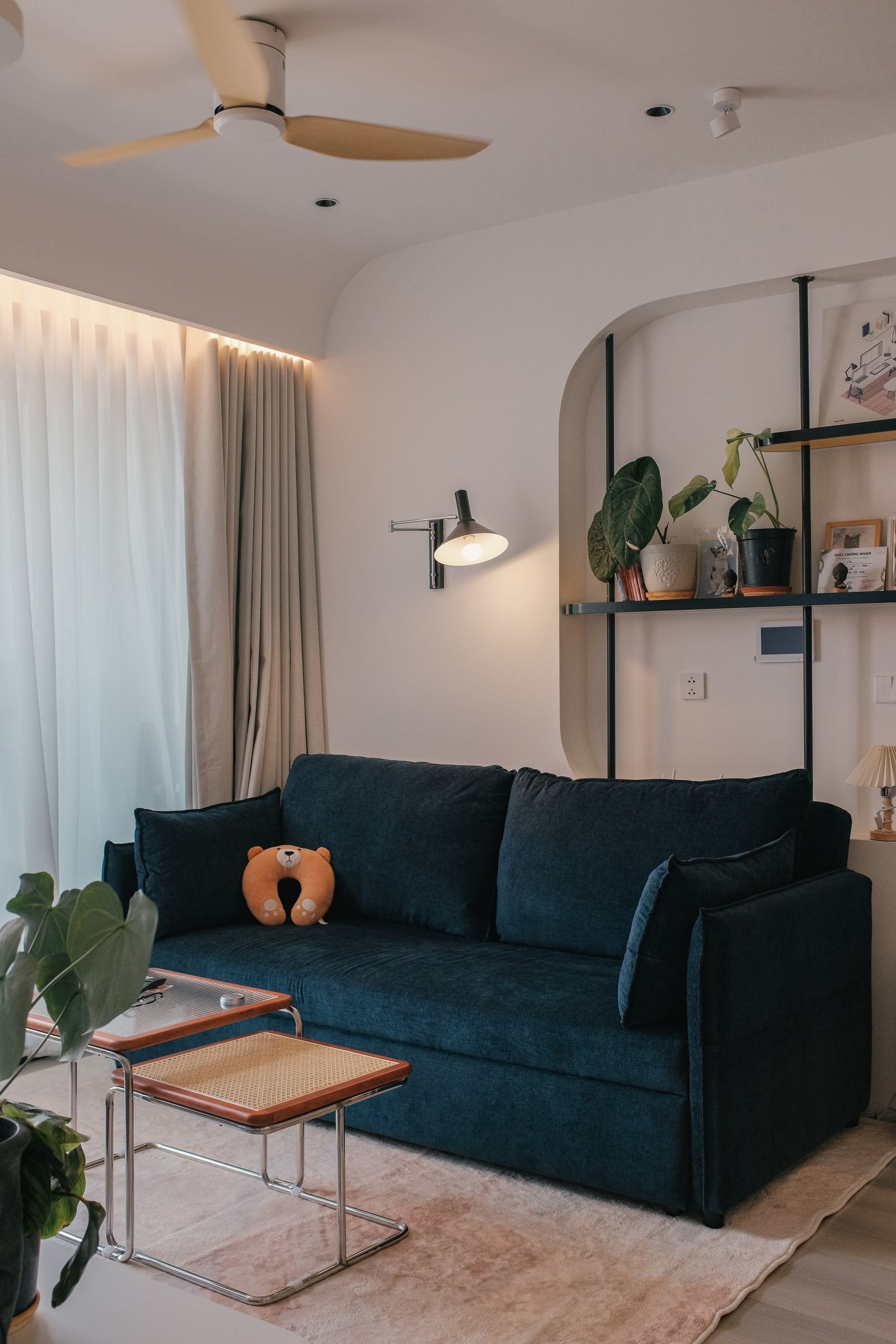 Gallery wall of framed art prints above a cosy living room sofa in warm tones