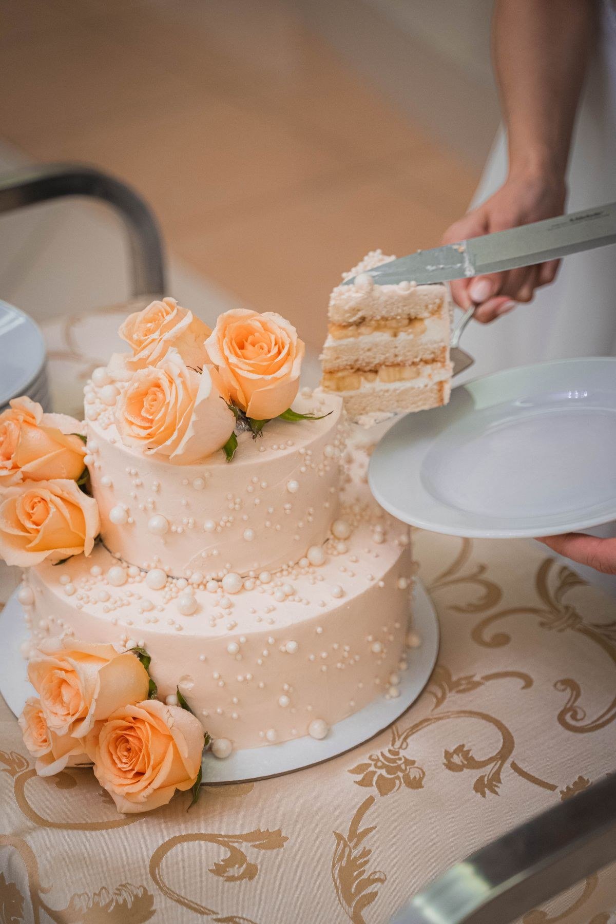 Couple cutting tiramisu wedding cake with cocoa dusting detail