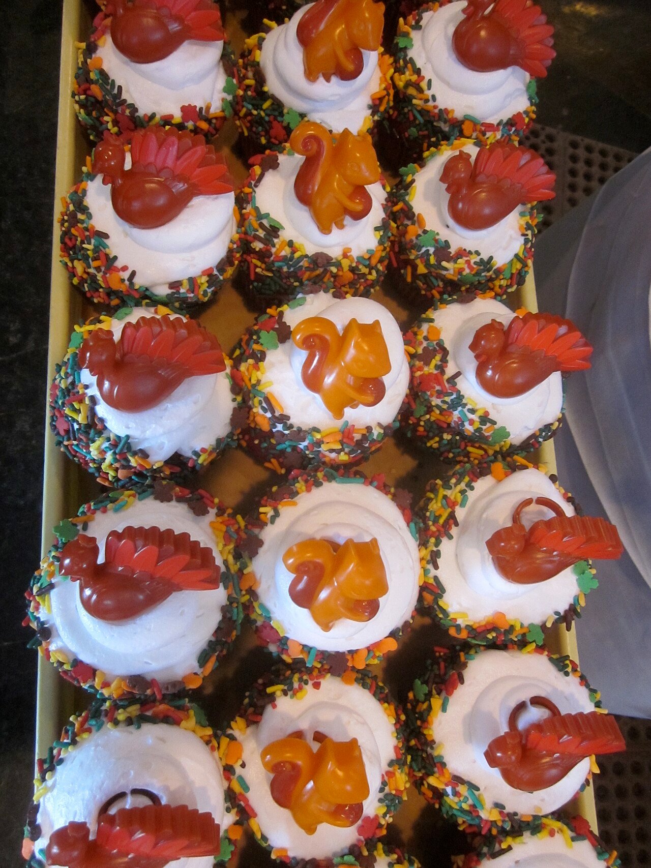 Turkey cupcakes displayed on a Thanksgiving dessert table with autumn decorations