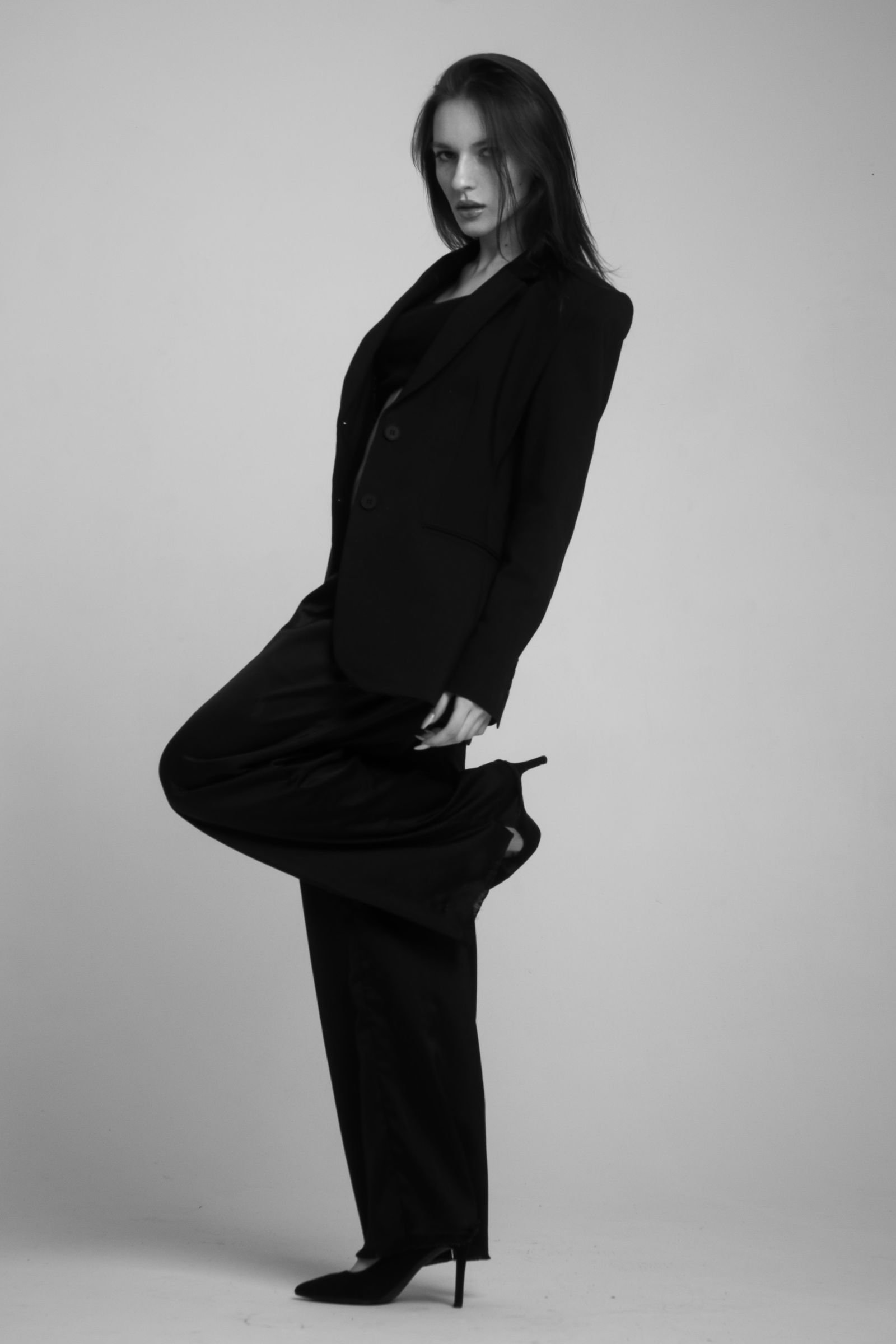 Woman model wearing classic camel cape coat with dark denim