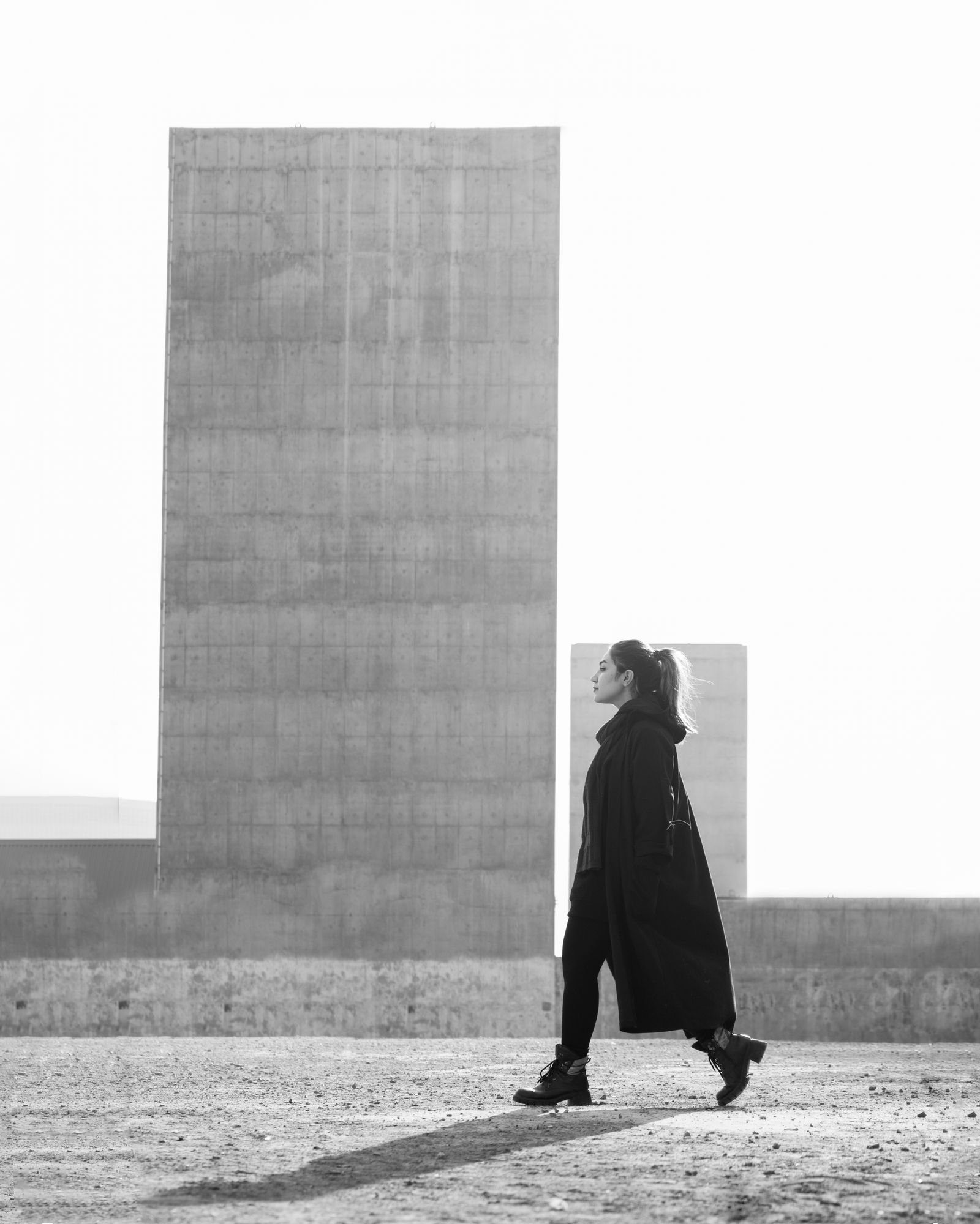 Woman walking near concrete structures in architectural cape