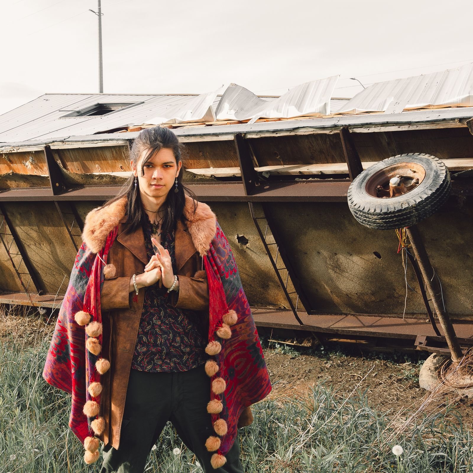 Man in fashionable boho outfit with cape coat outdoors