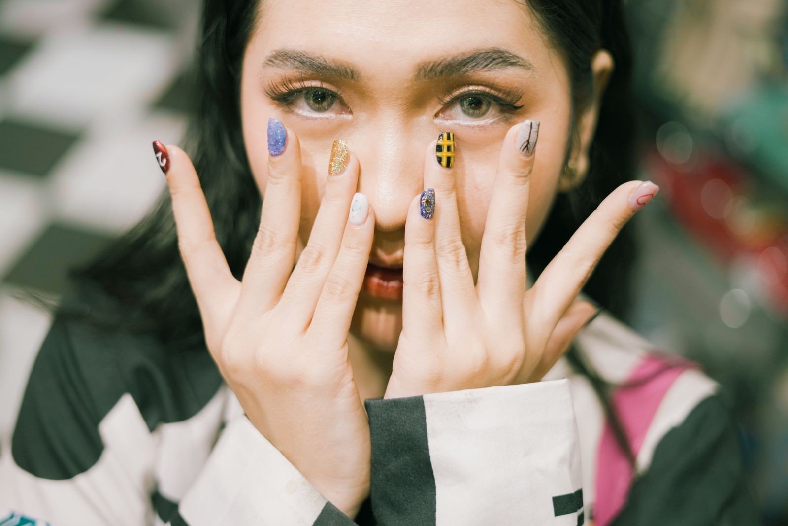 Applying top coat to mismatched manicure