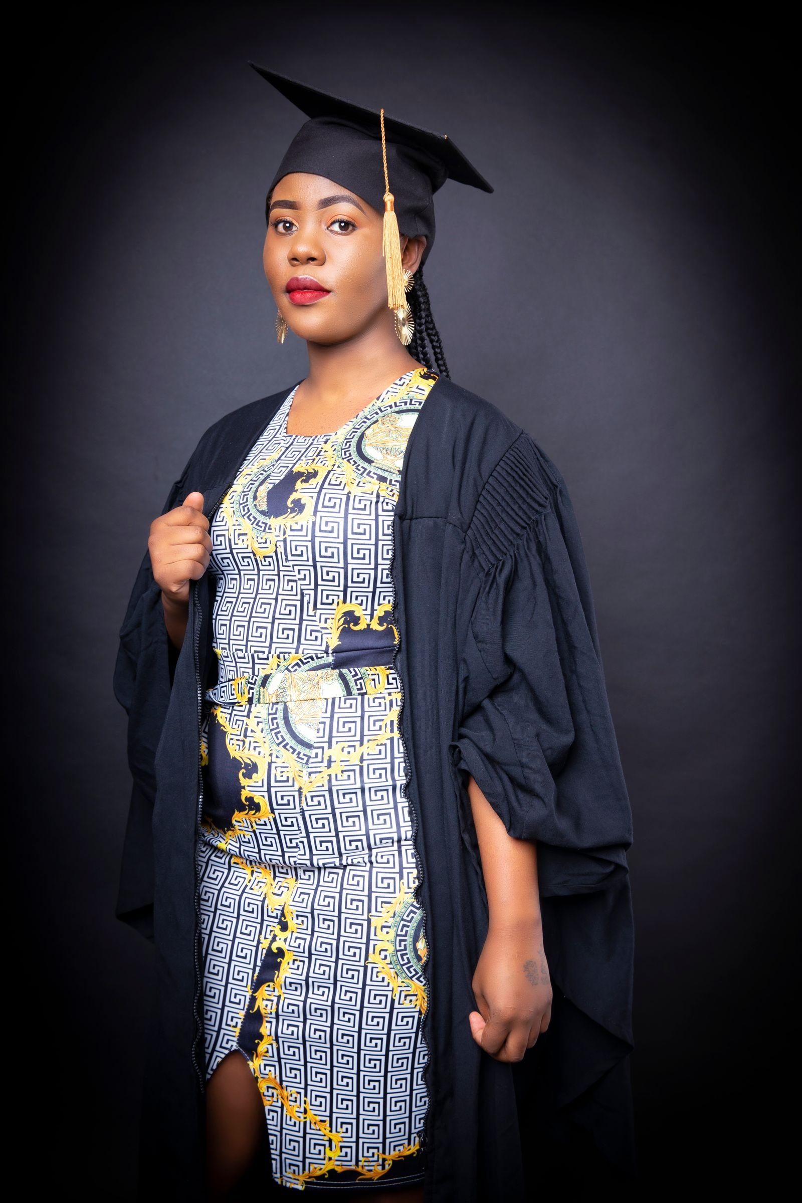 Elegant young woman in formal graduation style attire posing in a studio