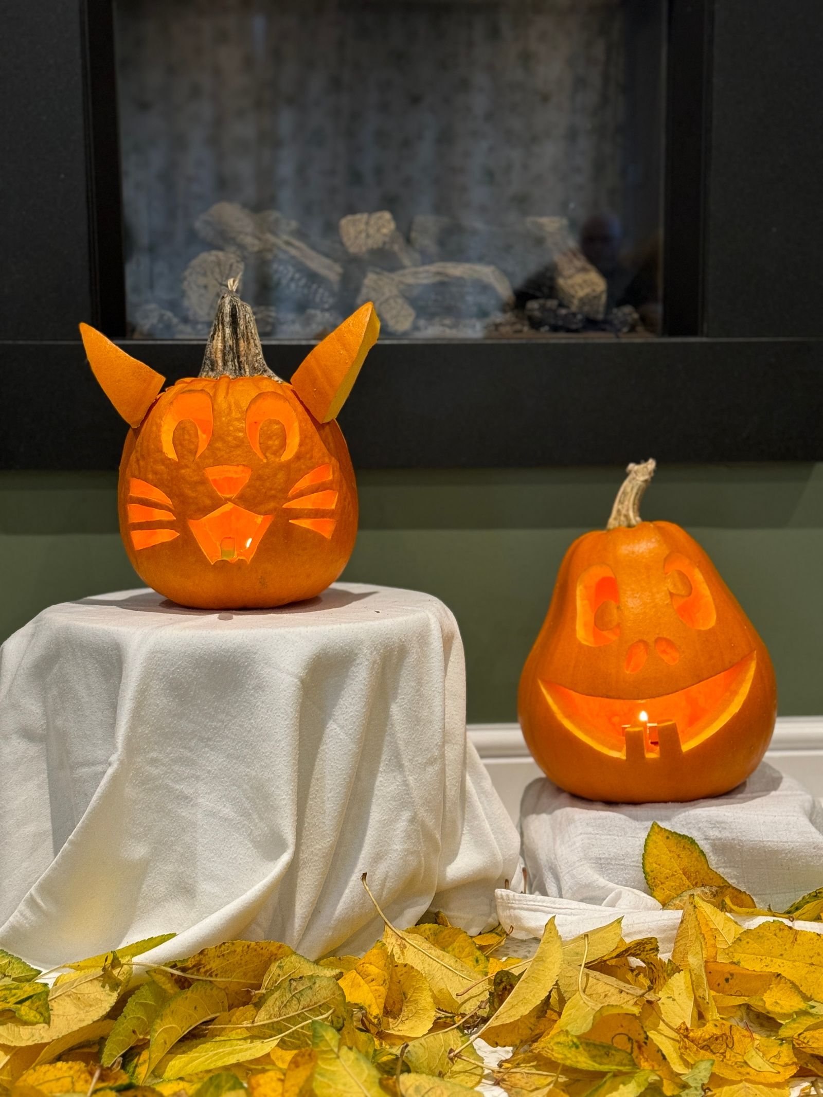 Older child carving a pumpkin with a stencil under adult supervision