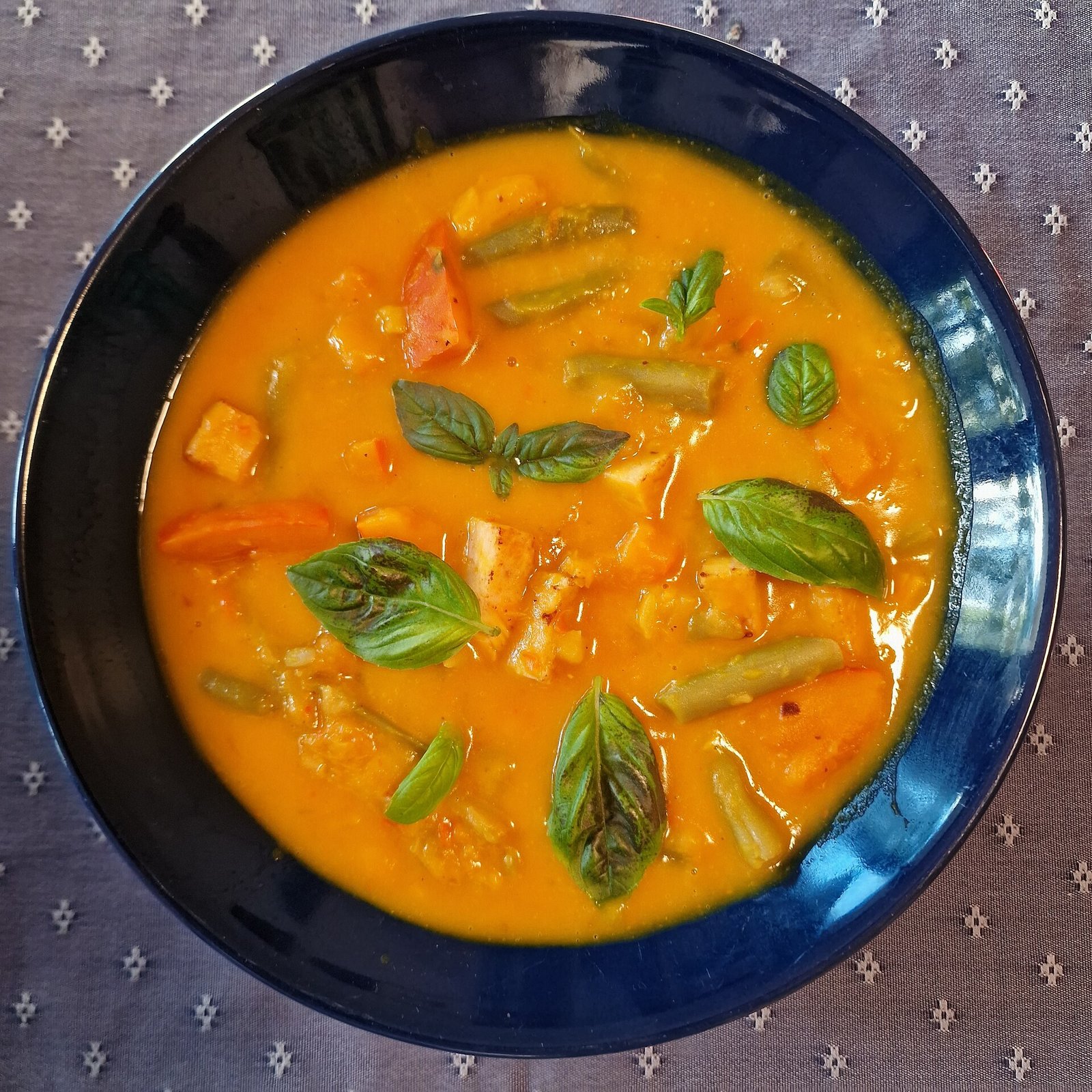 Ingredients for creamy pumpkin curry soup laid out on a rustic table
