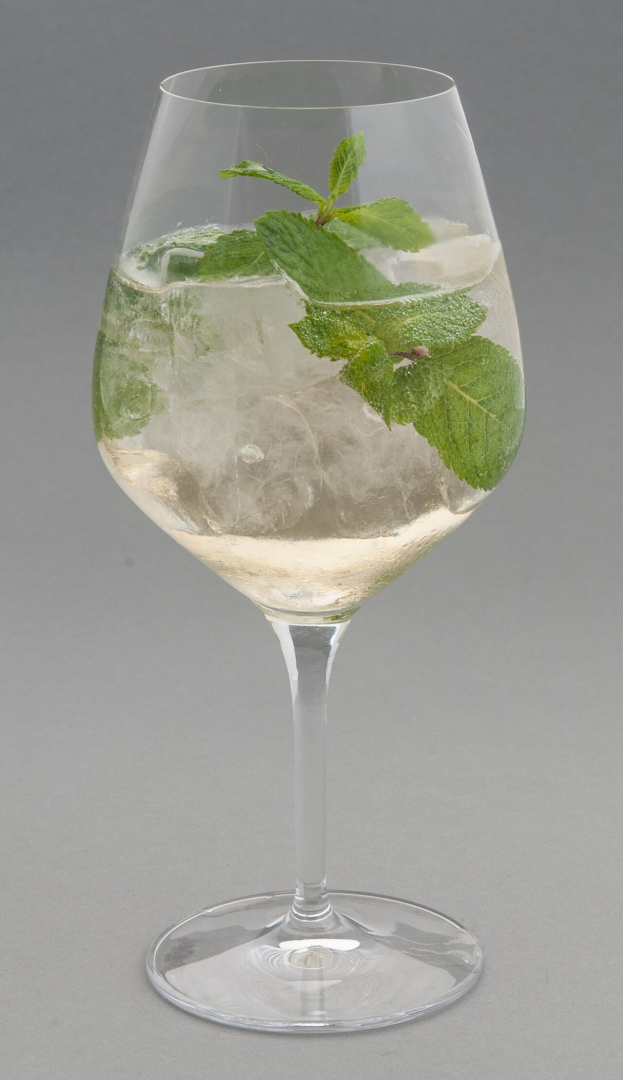 Assembling a Hugo spritz in a large wine glass