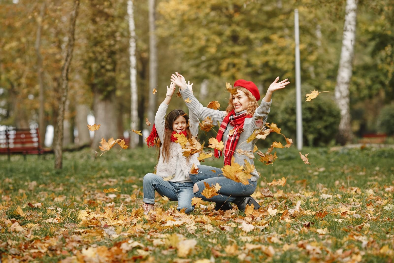 Joyful mother and daughter enjoying a playful moment in an autumn park
