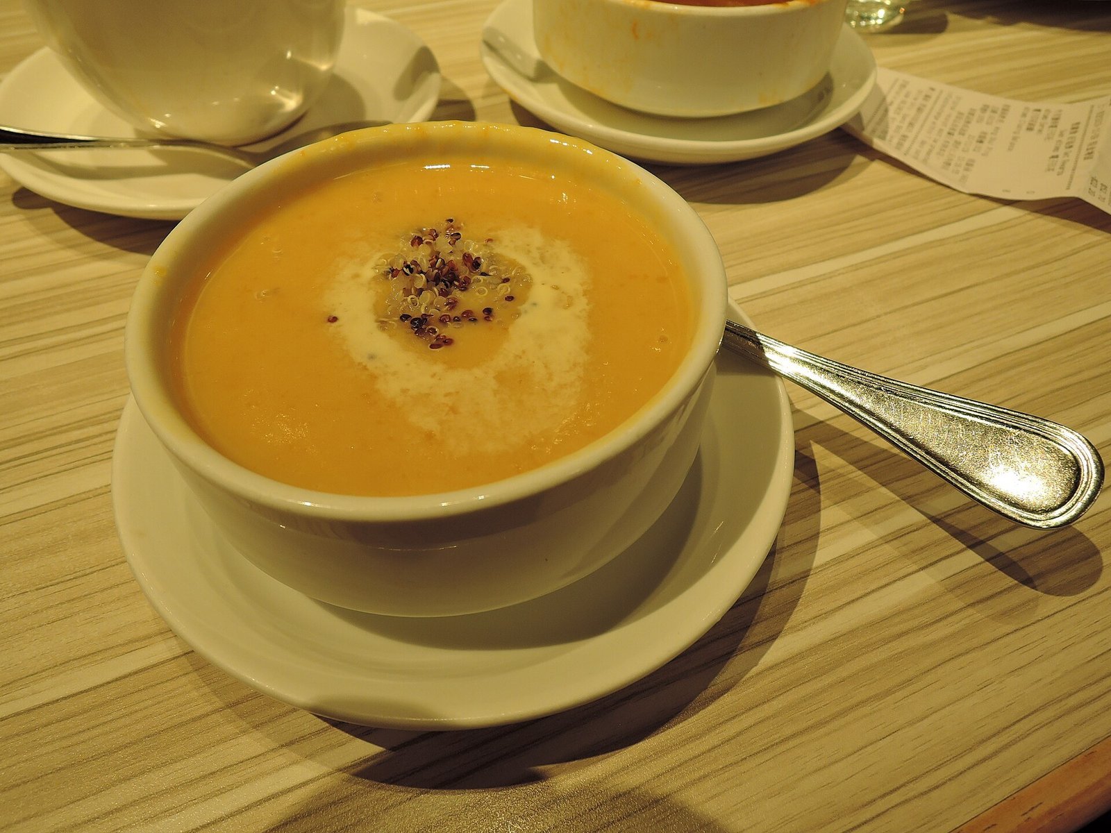 Family enjoying bowls of creamy pumpkin curry soup at an autumn table