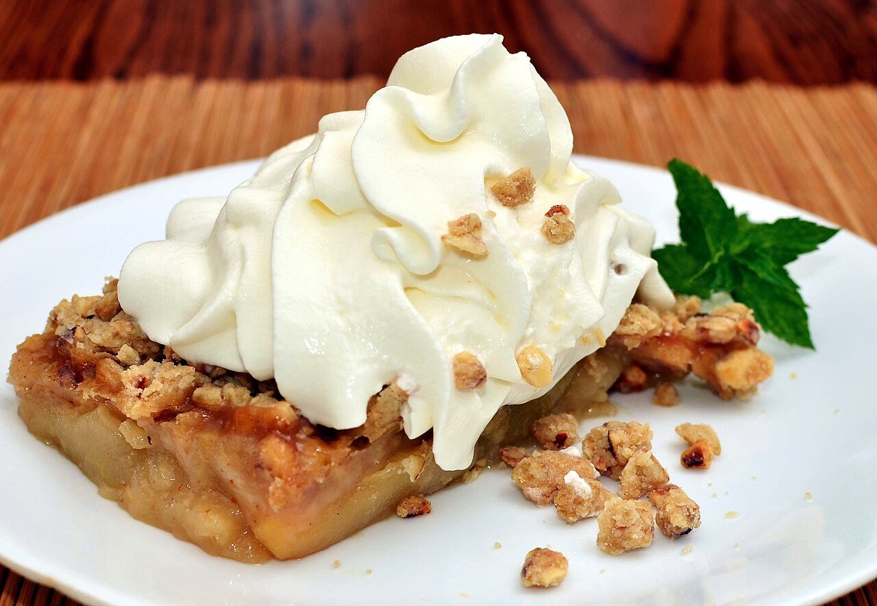 Cranberry apple crisp served with whipped cream