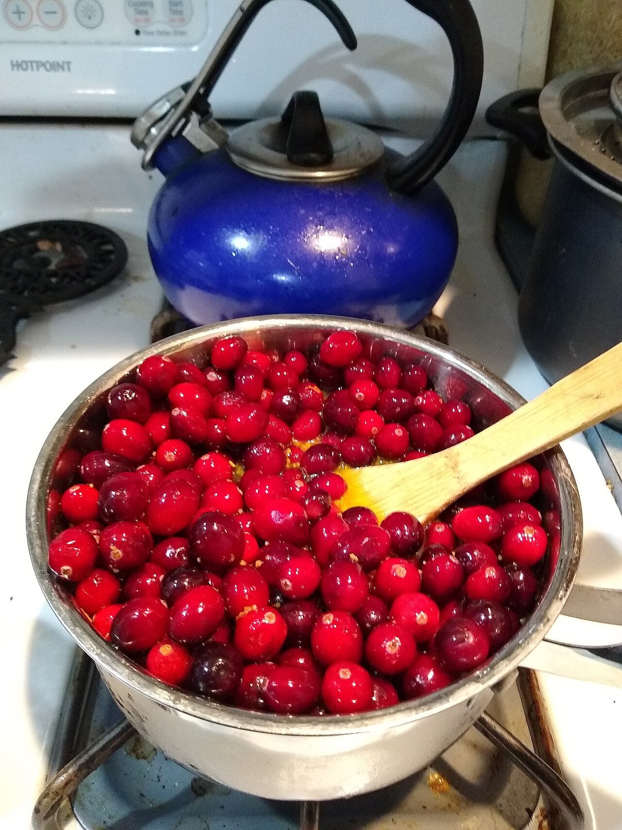 Cranberries simmering on the stovetop into a jammy sauce