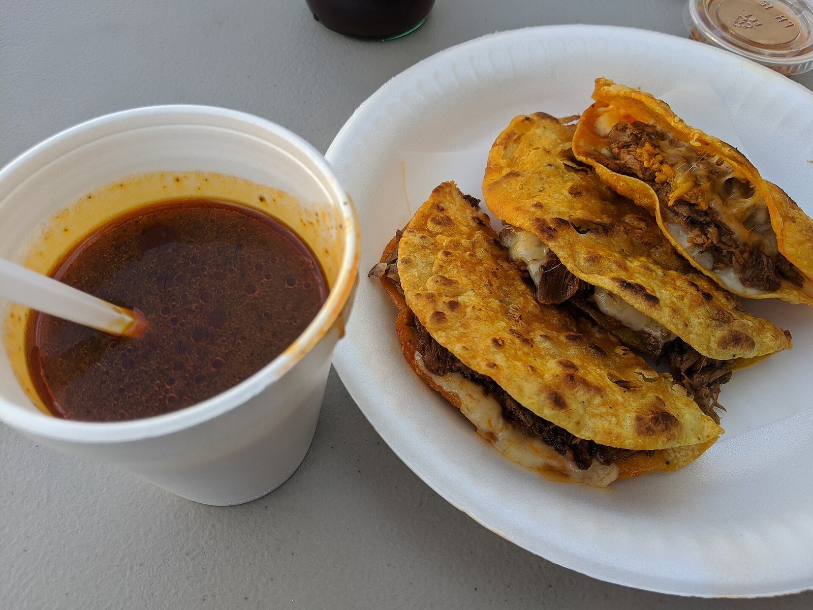 Birria tacos recipe topped with diced onion cilantro and lime wedges